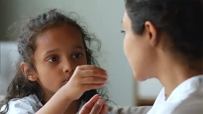 A young girl helping her friend with pronunciation